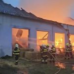Na Strakonicku hoří od večera bývalý kravín plný slámy. Ze střechy odlétával eternit