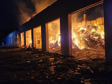 Na Strakonicku hoří od večera bývalý kravín plný slámy. Ze střechy odlétával eternit